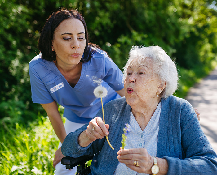 Caregivers assisting elderly person in wheelchair